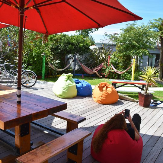 Relax on the deck at Kiwiana Backpackers Golden Bay